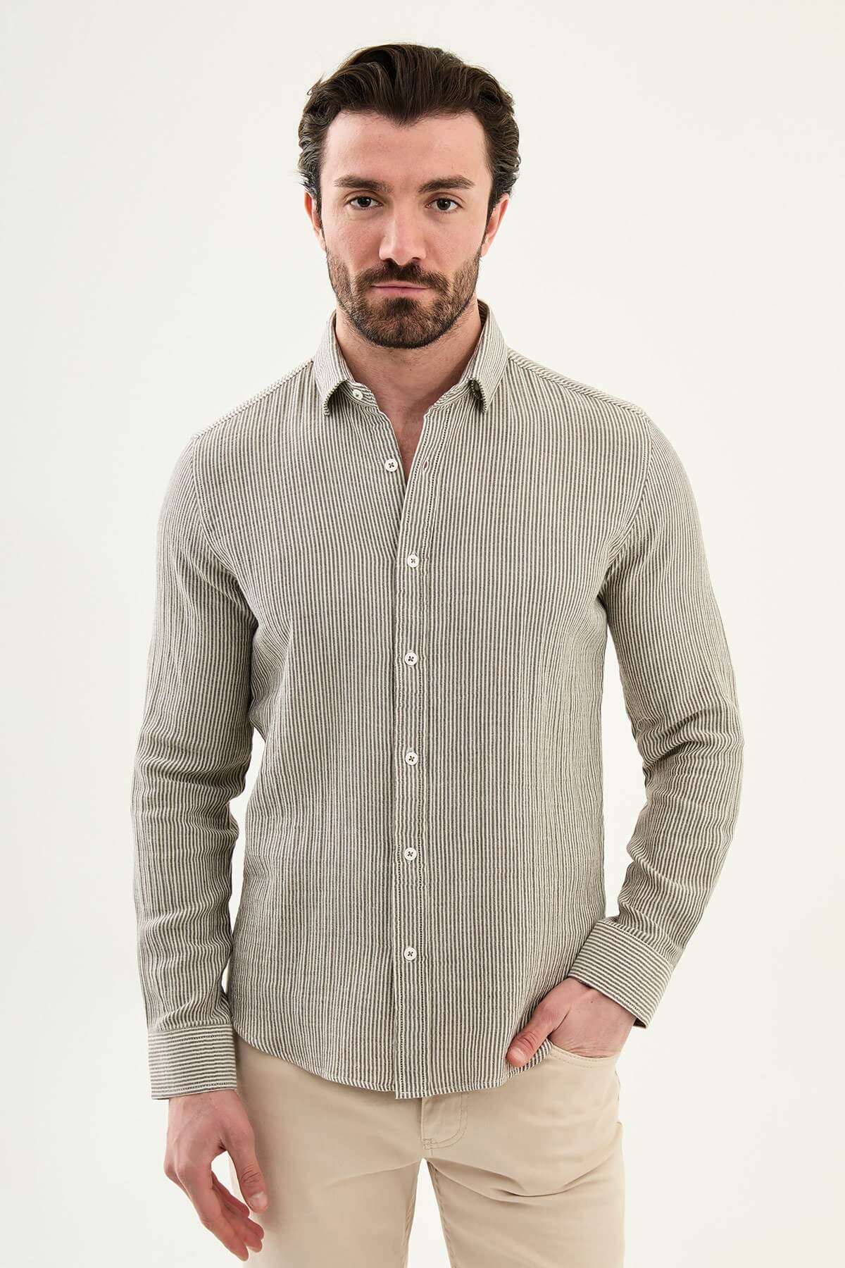 Men wearing a brown slim-fit long sleeve cotton shirt with a chest pocket, standing casually, showcasing the tailored fit and fabric texture.