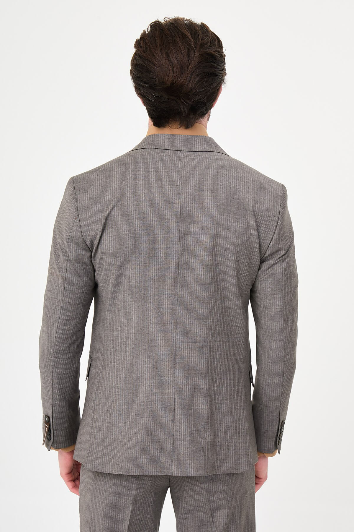 man in a Brown Slim Fit Wide Collar Premium Wool Suit, highlighting the slim-fit trousers and polished dress shoes.