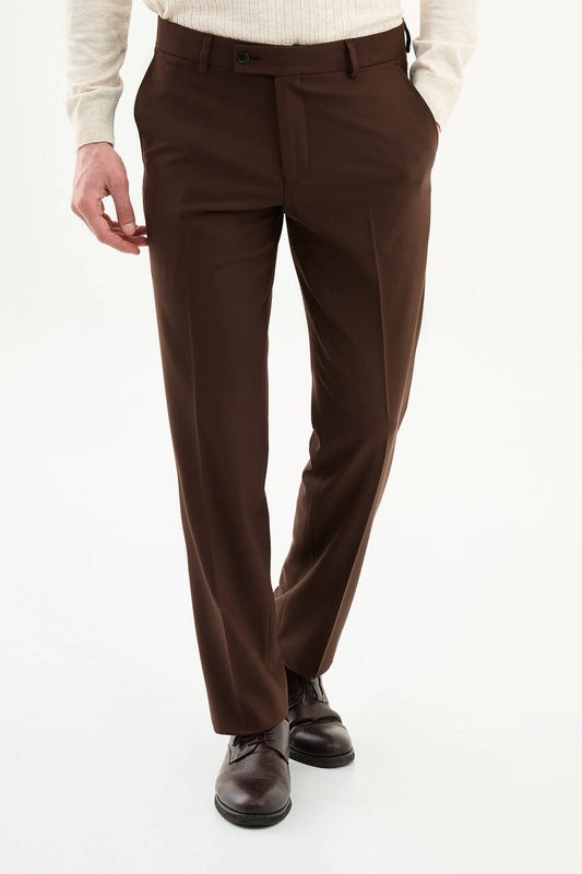 Man wearing brown pleated dress trousers with a straight slim fit, styled with a white shirt and brown leather shoes.