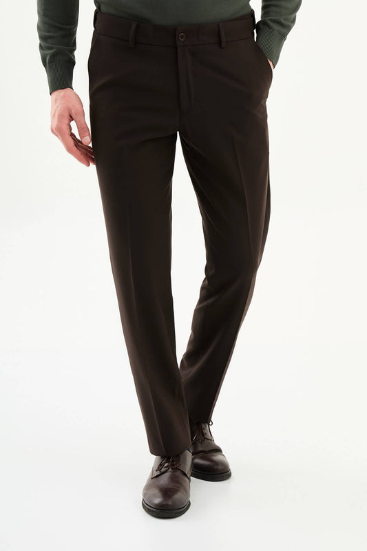 Man wearing brown slim-fit dress trousers styled with a green dress shirt and brown leather shoes.