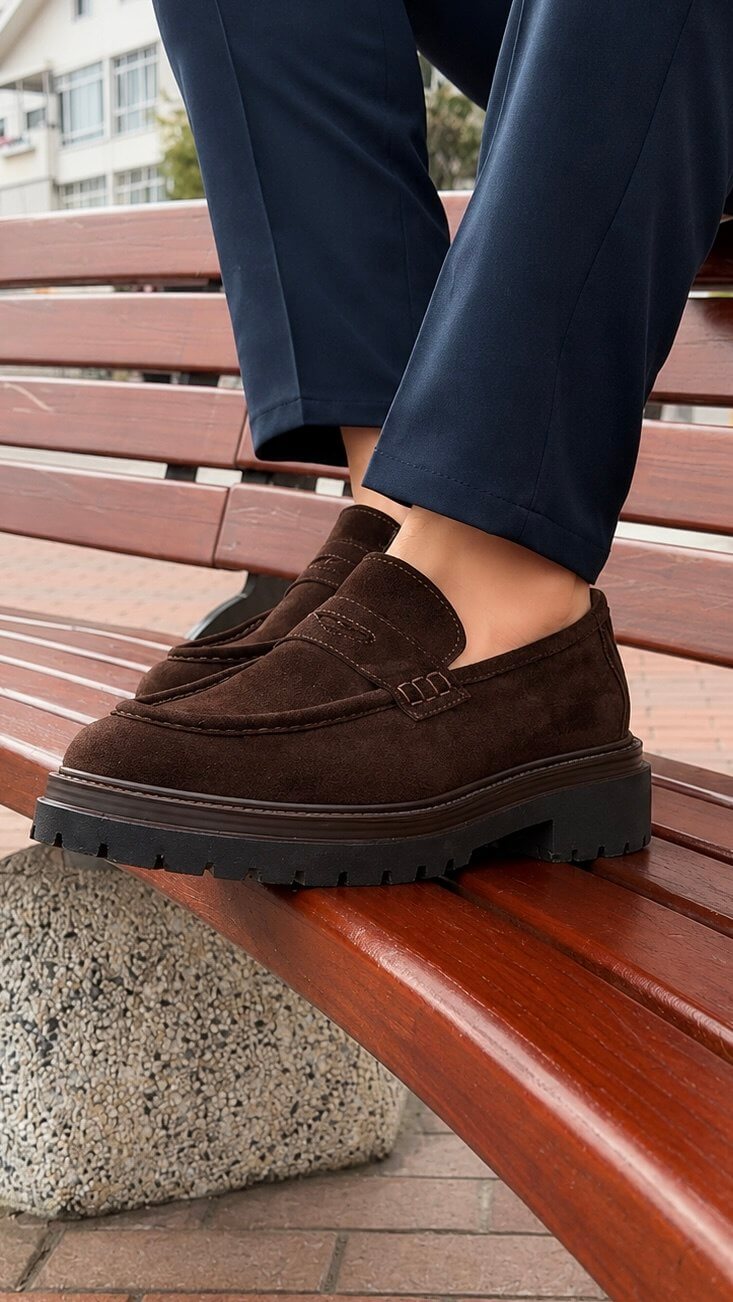 Brown suede penny loafer, close-up of penny slot strap detail