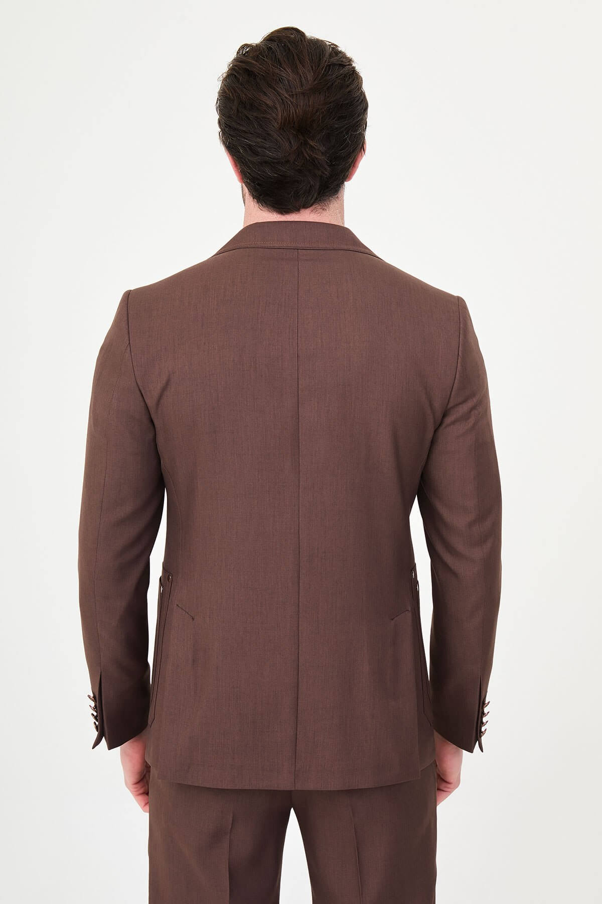 a brown slim-fit two-piece wedding suit with notch lapels, utility-style stitched lower pockets, cream knitwear, matching tailored trousers, and dark brown leather shoes.