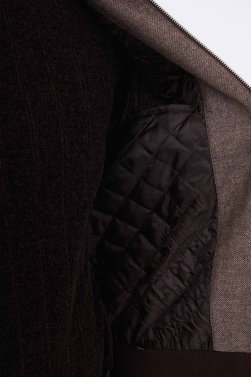 Brown men's casual jacket styled with a black sweater and dark jeans.