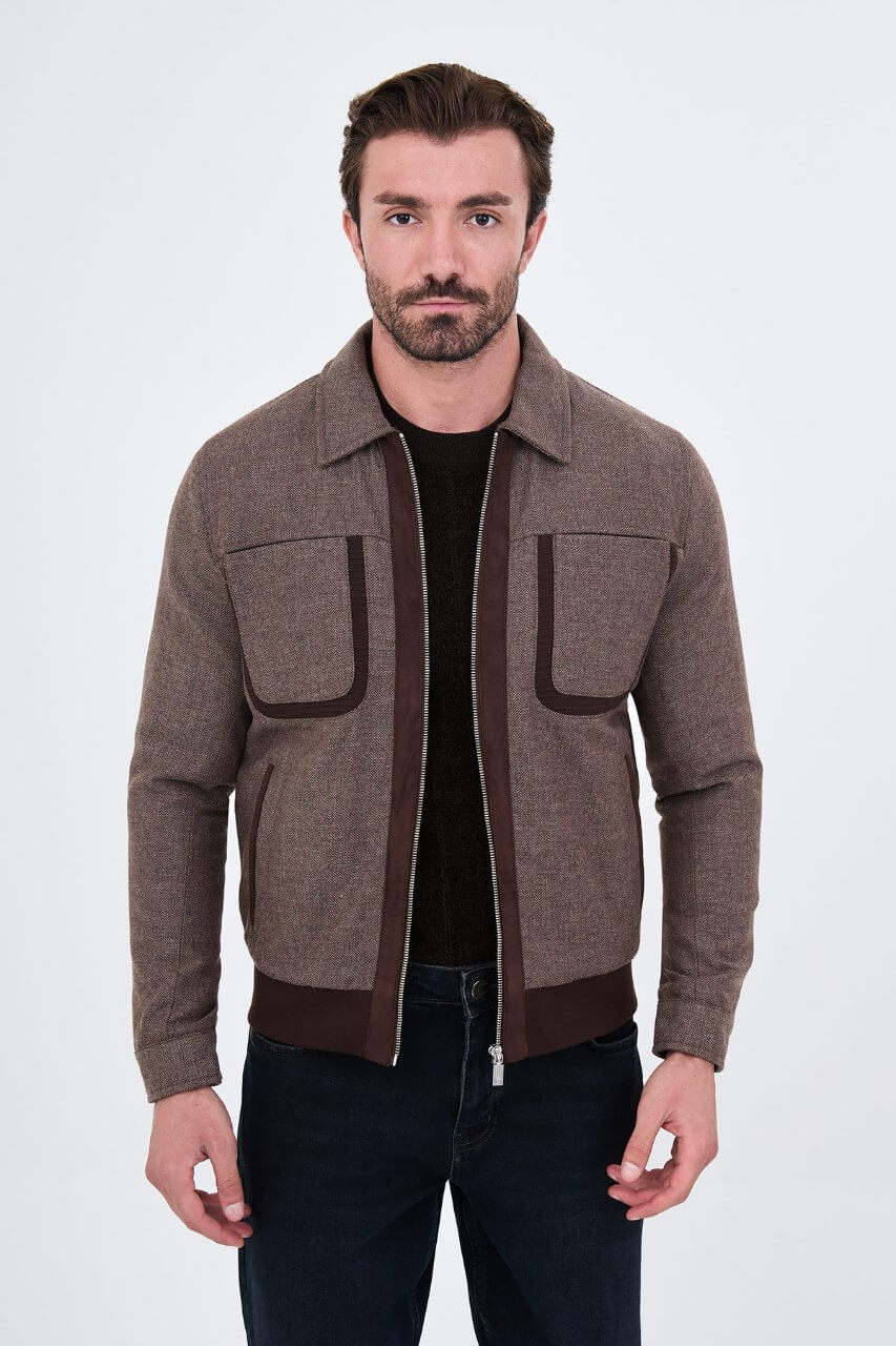 Brown men's casual jacket styled with a black sweater and dark jeans.
