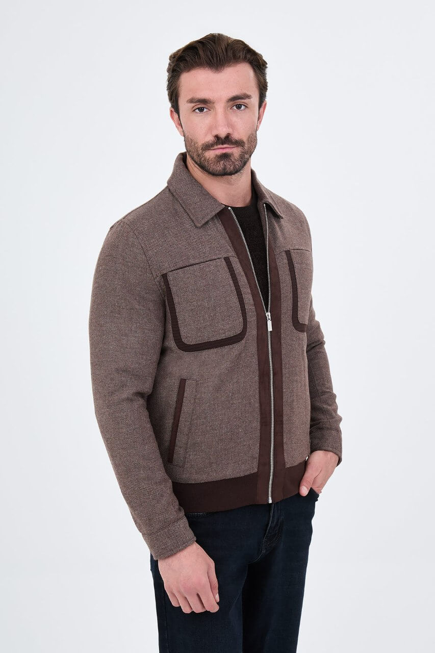 Brown men's casual jacket styled with a black sweater and dark jeans.