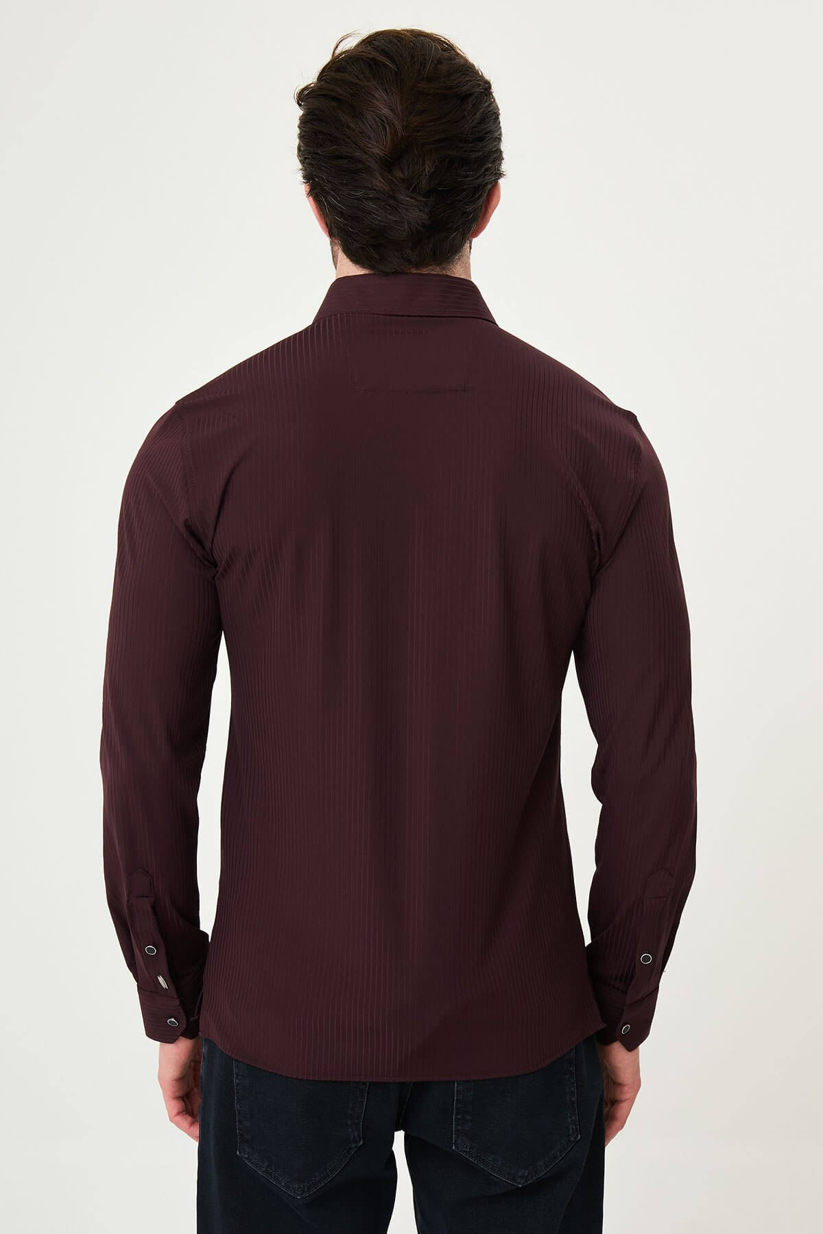 Burgundy slim-fit men’s shirt with vertical stripes, long sleeves, and a classic collar, styled with dark trousers.