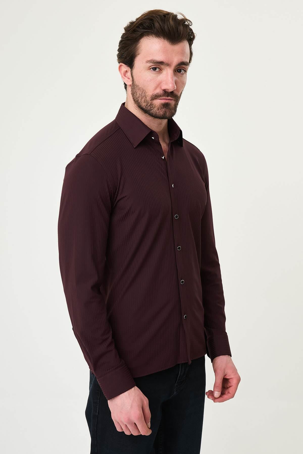 Burgundy slim-fit men’s shirt with vertical stripes, long sleeves, and a classic collar, styled with dark trousers.