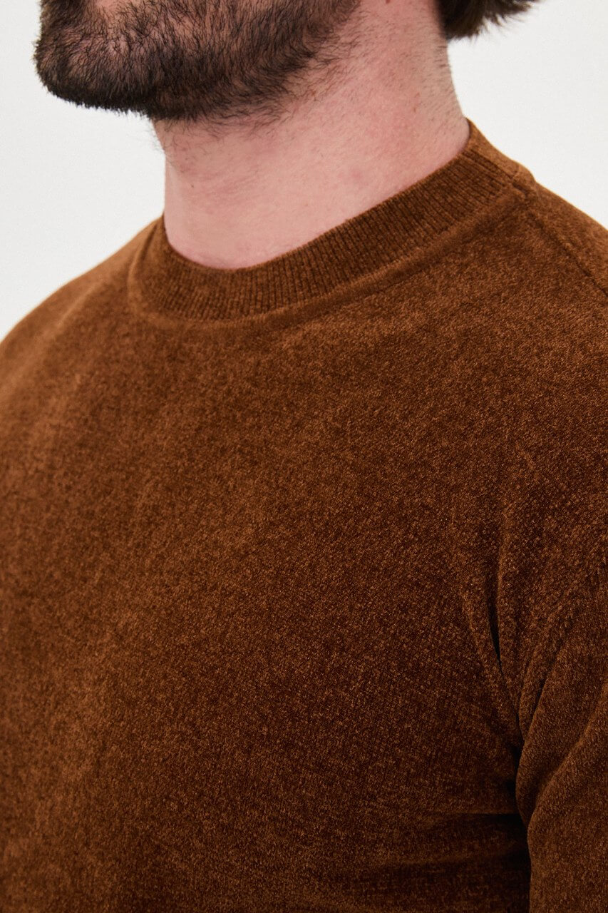 Men’s camel crew neck knit sweater in a cotton blend slim fit design styled with brown trousers for a refined fall winter outfit.