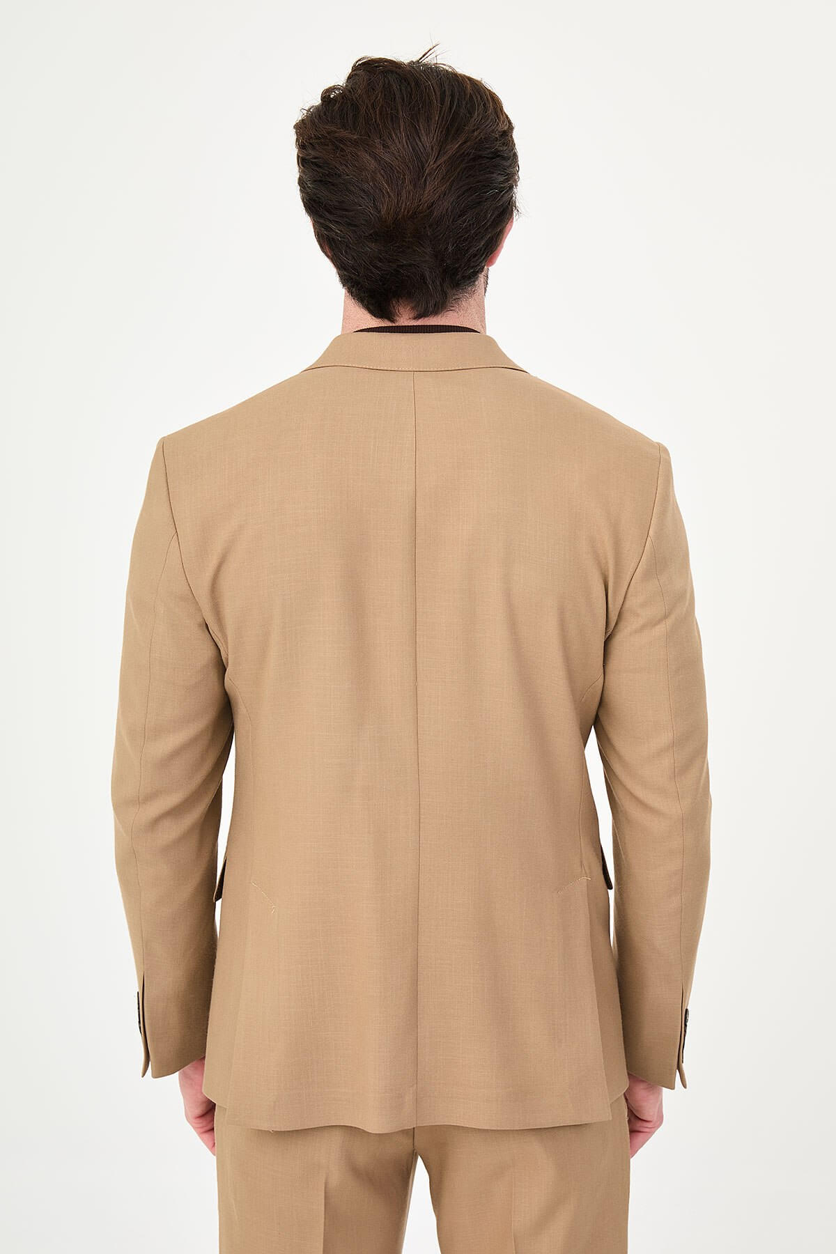 a camel slim-fit double-breasted linen-blend suit with peak lapels, dark buttons, matching trousers, a dark brown knit polo, and brown leather sneakers.