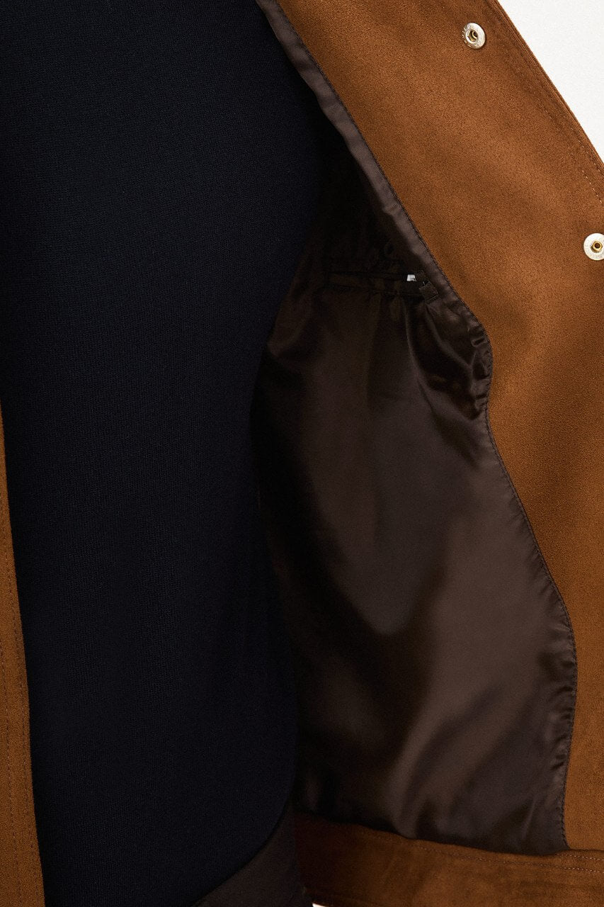 Men's camel suede-style jacket styled with a black sweater and dark trousers.