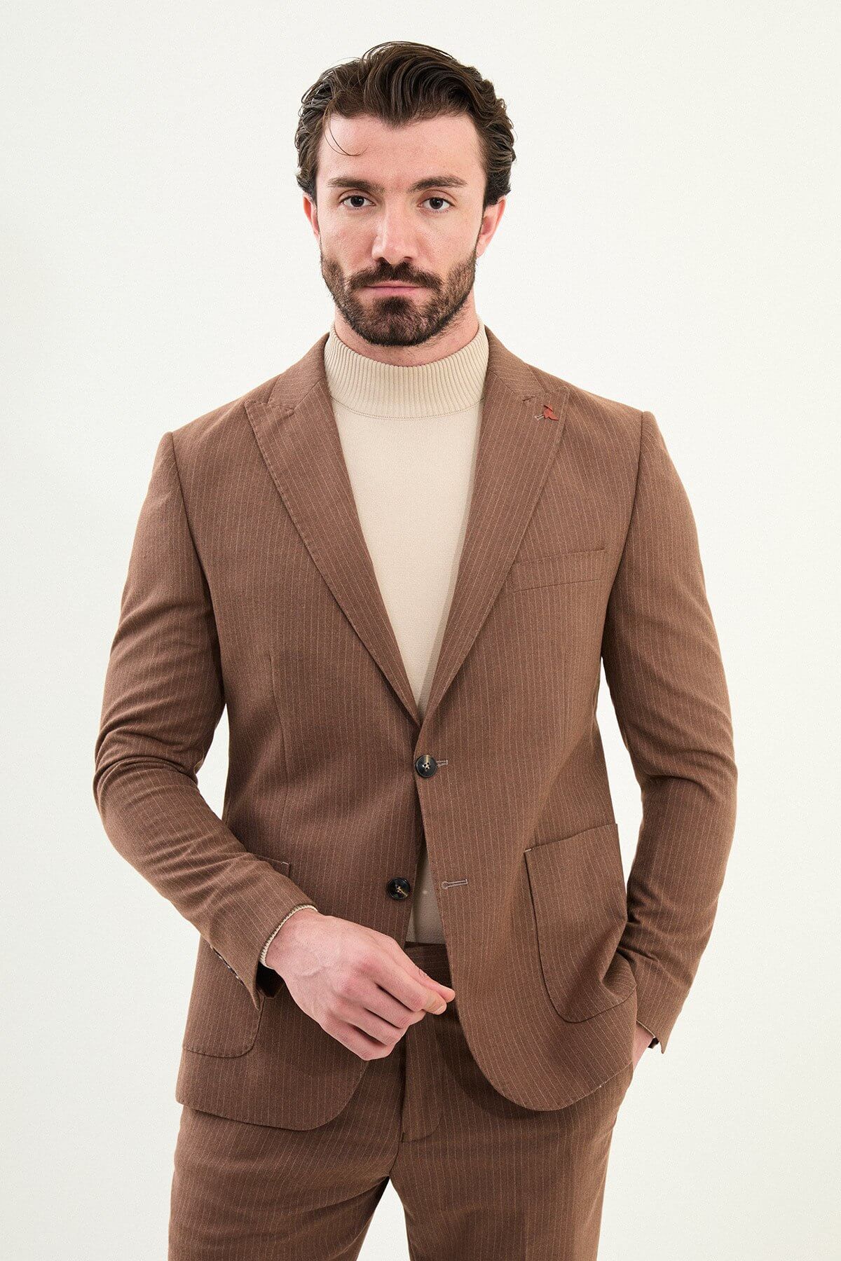 Men’s camel slim-fit mono-collar suit with pointed minimalist collar, matte micro-texture fabric, single-breasted jacket, and styled with a cream turtleneck for tonal winter dressing.
