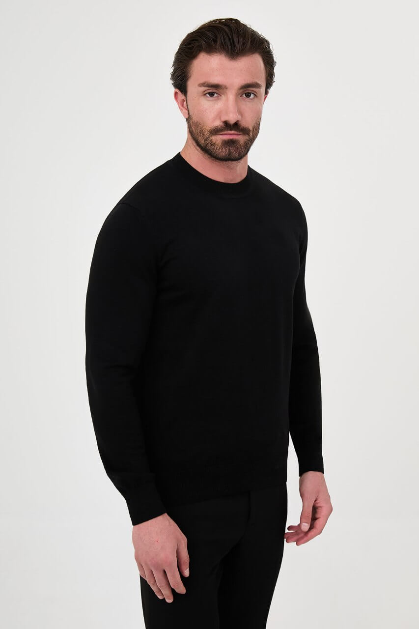 Men’s black cotton crewneck knit sweater styled with black trousers for fall winter fashion