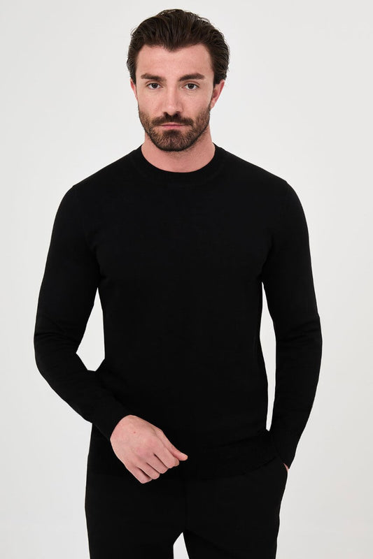 Men’s black cotton crewneck knit sweater styled with black trousers for fall winter fashion