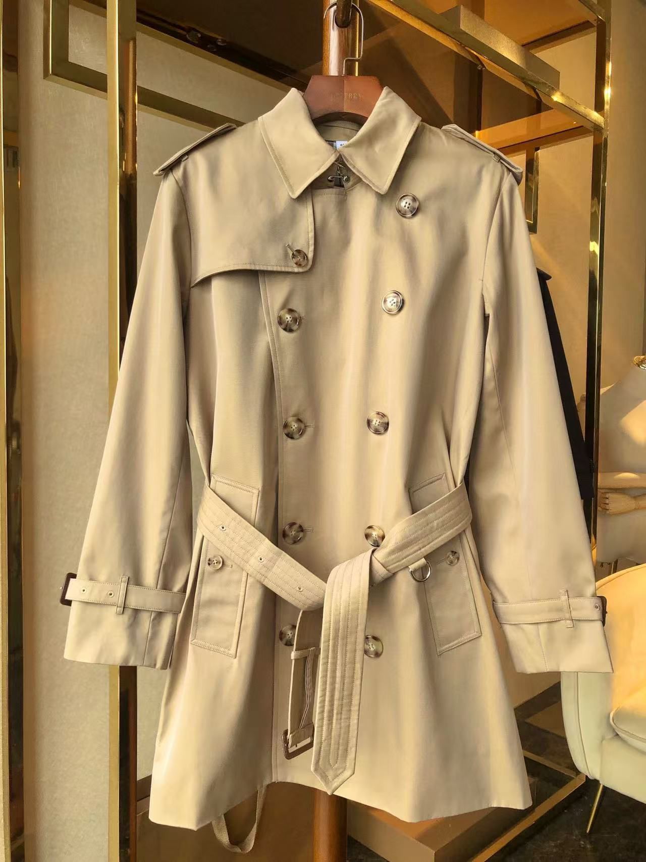 men’s beige double-breasted trench coat with belt and epaulets on hanger