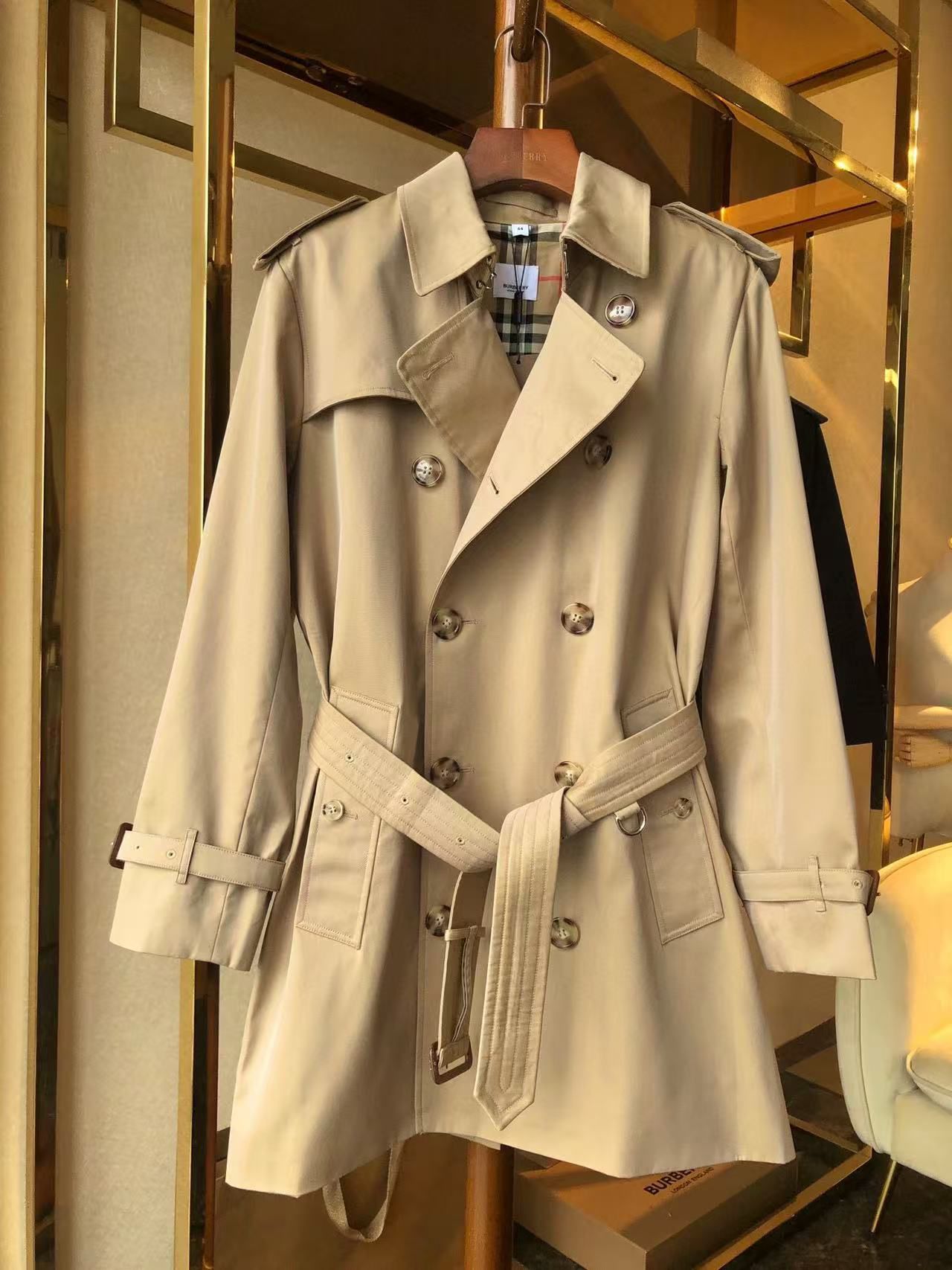men’s beige double-breasted trench coat with belt and epaulets on hanger