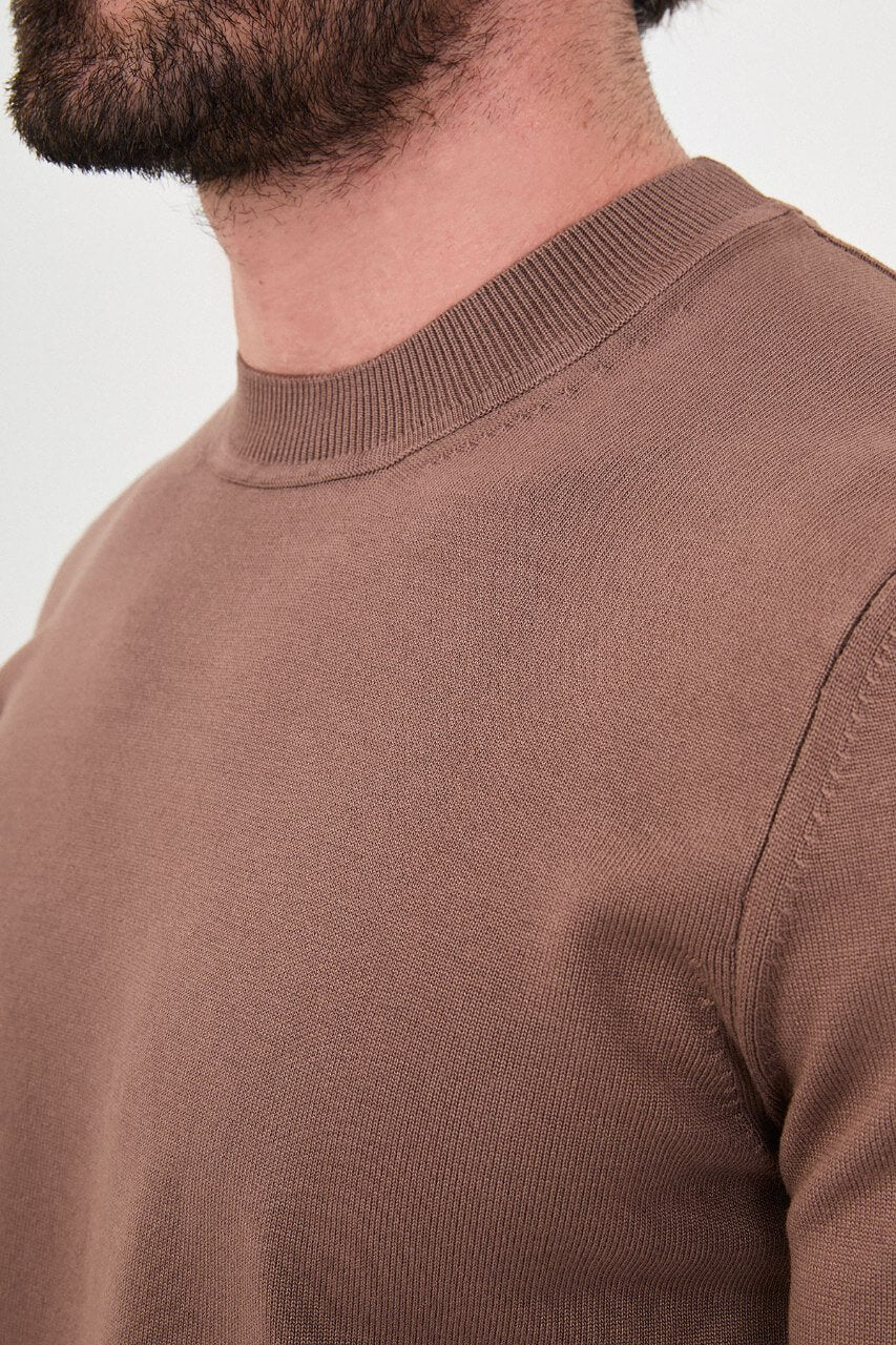 Men’s light brown cotton crewneck knit sweater styled with black trousers for fall winter fashion