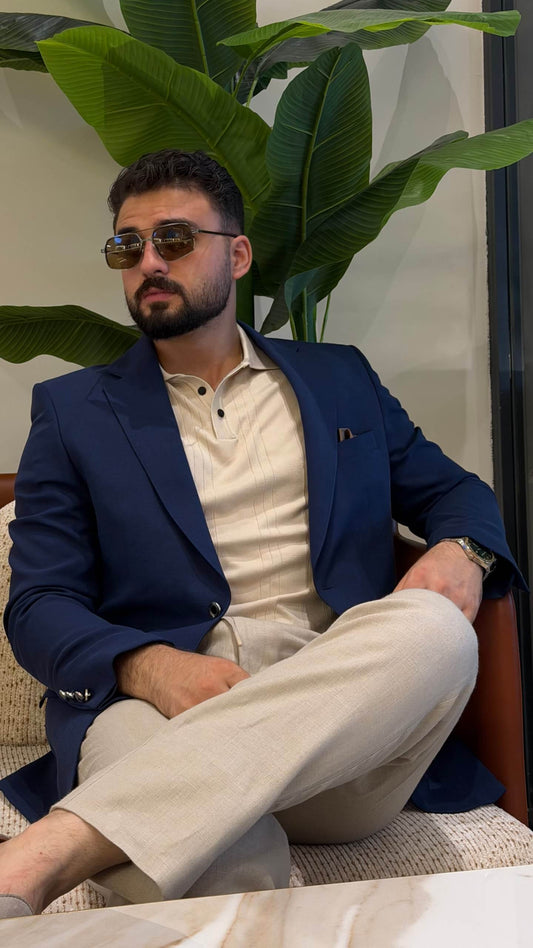 Men’s navy blue wool blend blazer styled with cream polo shirt and tailored trousers