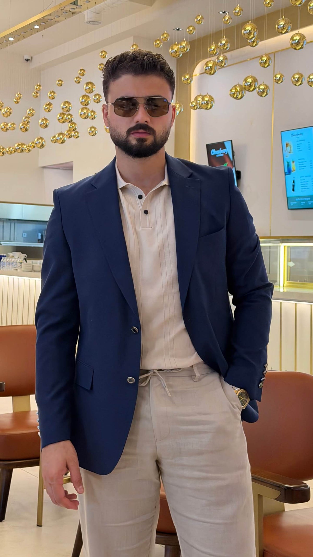 Men’s navy blue wool blend blazer styled with cream polo shirt and tailored trousers