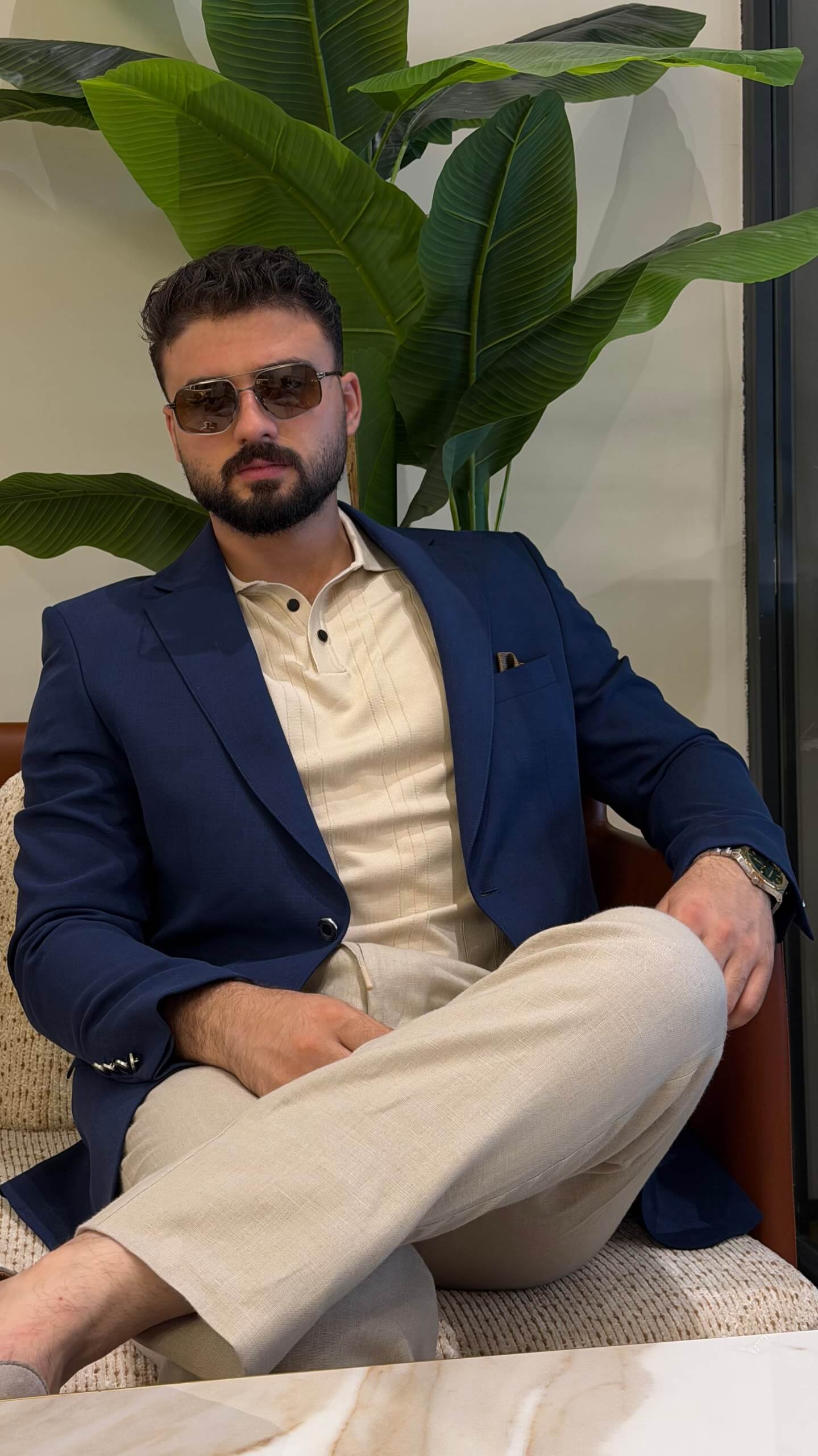 Men’s navy blue wool blend blazer styled with cream polo shirt and tailored trousers