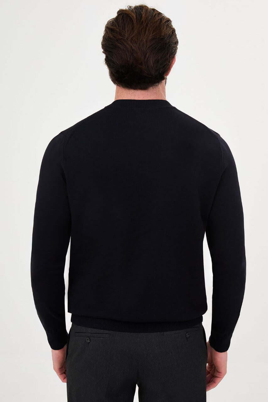 Men’s navy blue crewneck cotton knit sweater styled with black trousers for fall winter fashion