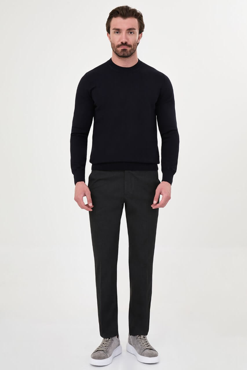 Men’s navy blue crewneck cotton knit sweater styled with black trousers for fall winter fashion