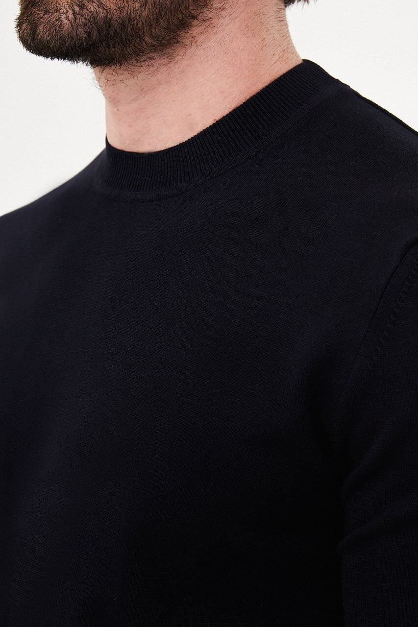 Men’s navy blue crewneck cotton knit sweater styled with black trousers for fall winter fashion