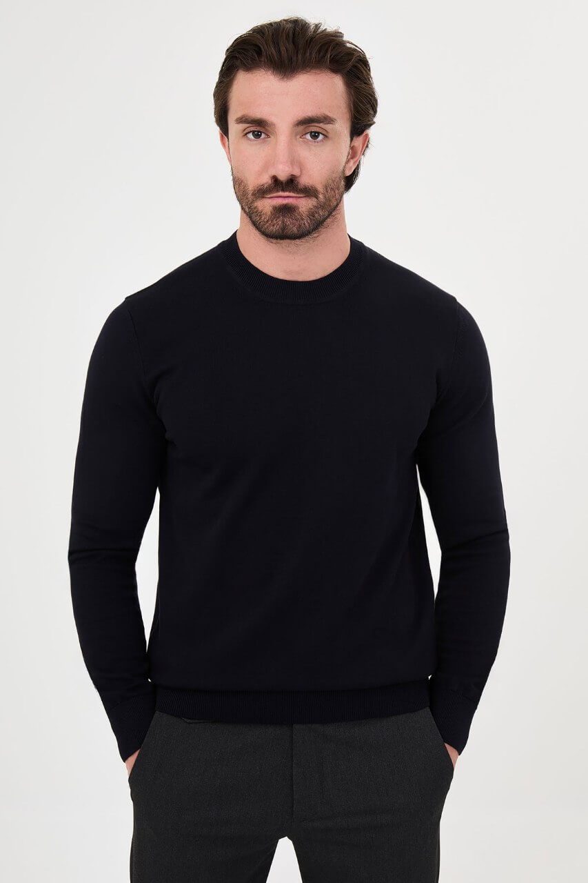 Men’s navy blue crewneck cotton knit sweater styled with black trousers for fall winter fashion