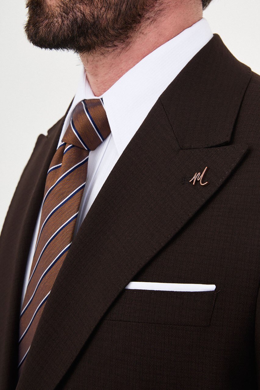 Men's brown slim-fit two-piece suit with a tailored blazer, notch lapels and matching trousers.