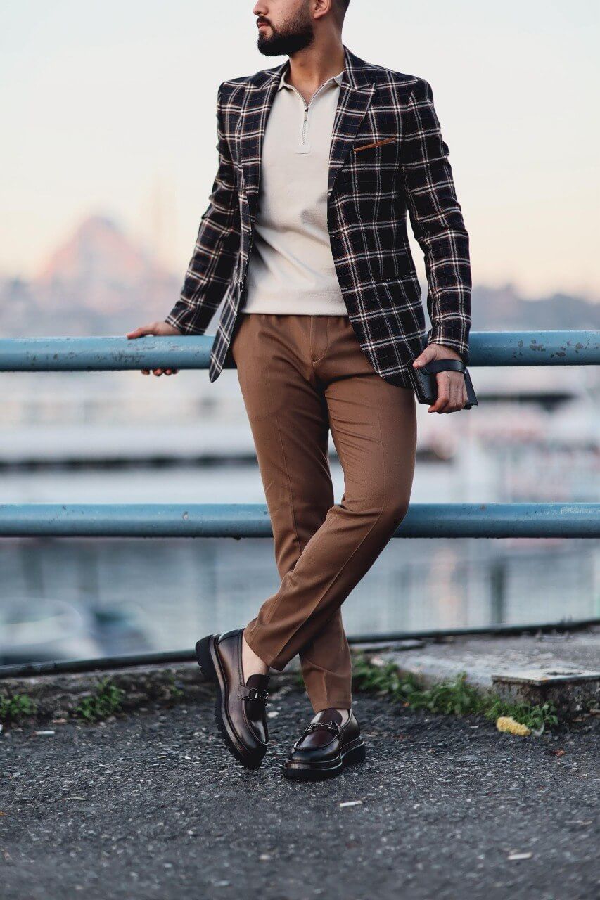 Men’s dark blue plaid mono-collar slim-fit jacket styled with beige knit top and brown trousers