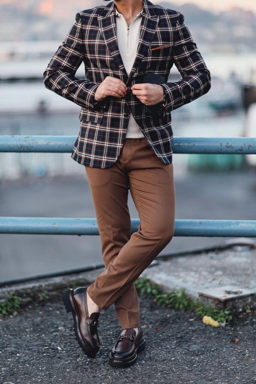 Men’s dark blue plaid mono-collar slim-fit jacket styled with beige knit top and brown trousers