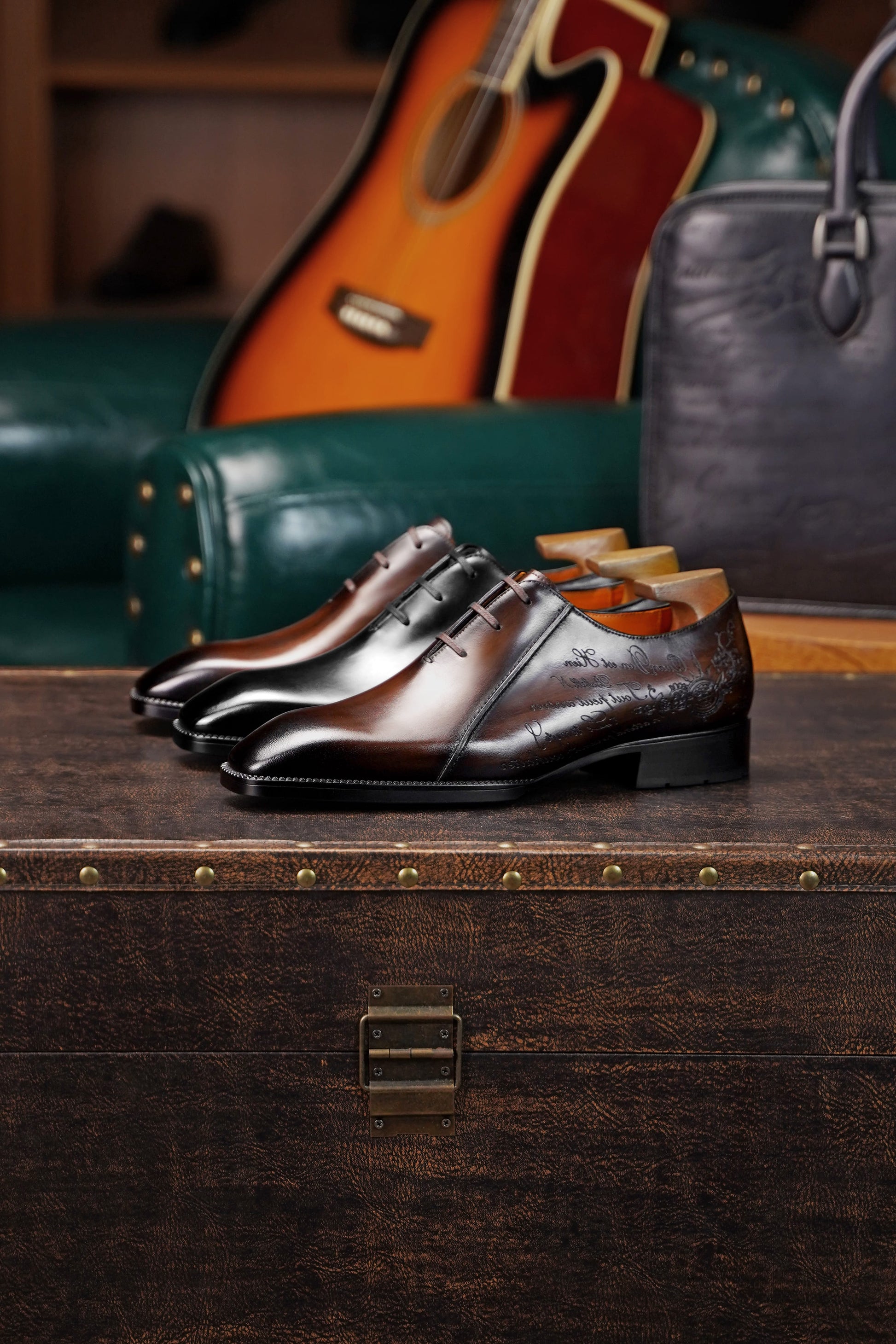 Men’s dark brown leather Oxford dress shoes with lace-up design, polished finish, pointed toe silhouette, and embossed script detail on the side panel.