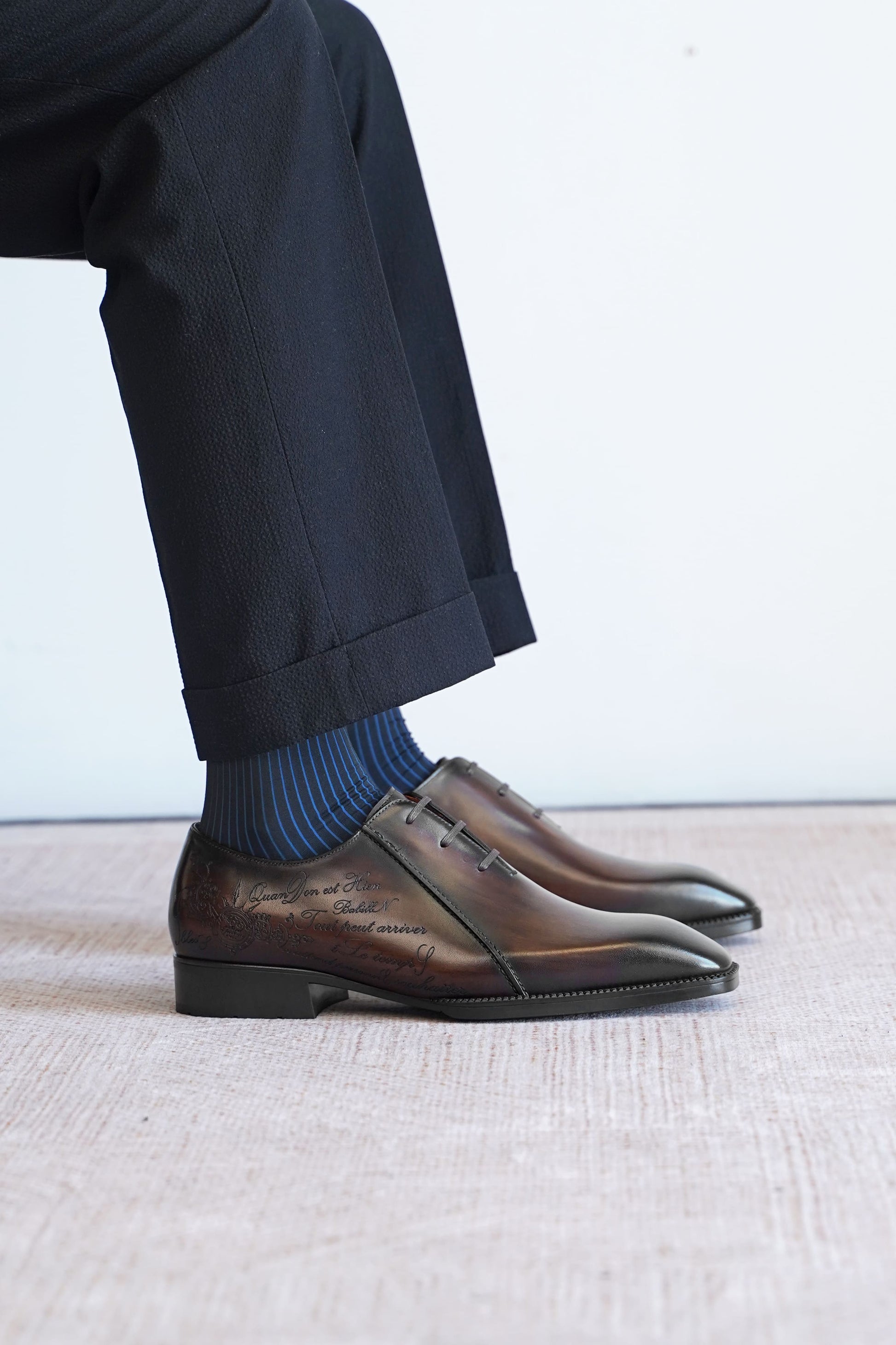 Men’s dark brown leather Oxford dress shoes with lace-up design, polished finish, pointed toe silhouette, and embossed script detail on the side panel.