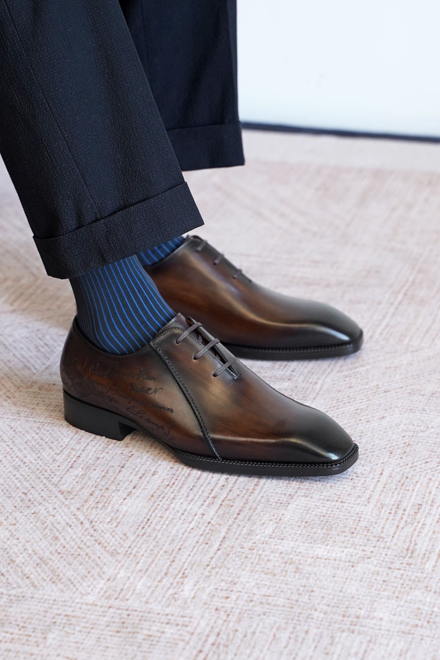Men’s dark brown leather Oxford dress shoes with lace-up design, polished finish, pointed toe silhouette, and embossed script detail on the side panel.