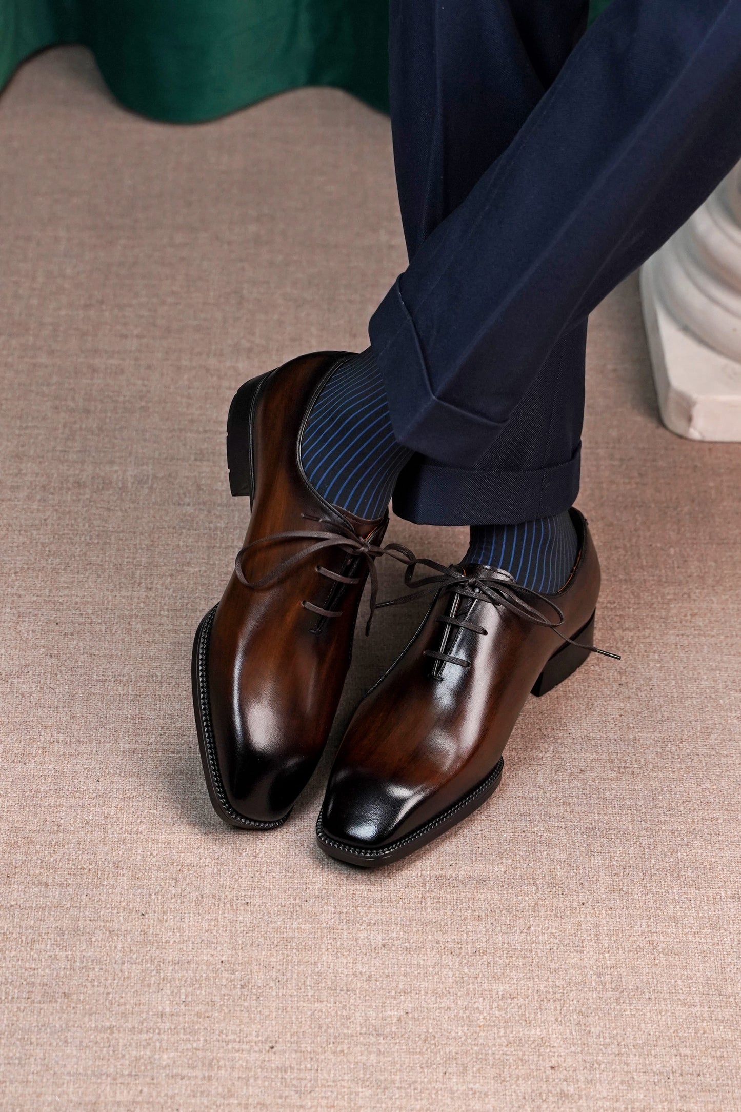 Men’s dark brown leather Oxford dress shoes with lace-up design, polished finish, pointed toe silhouette, and embossed script detail on the side panel.