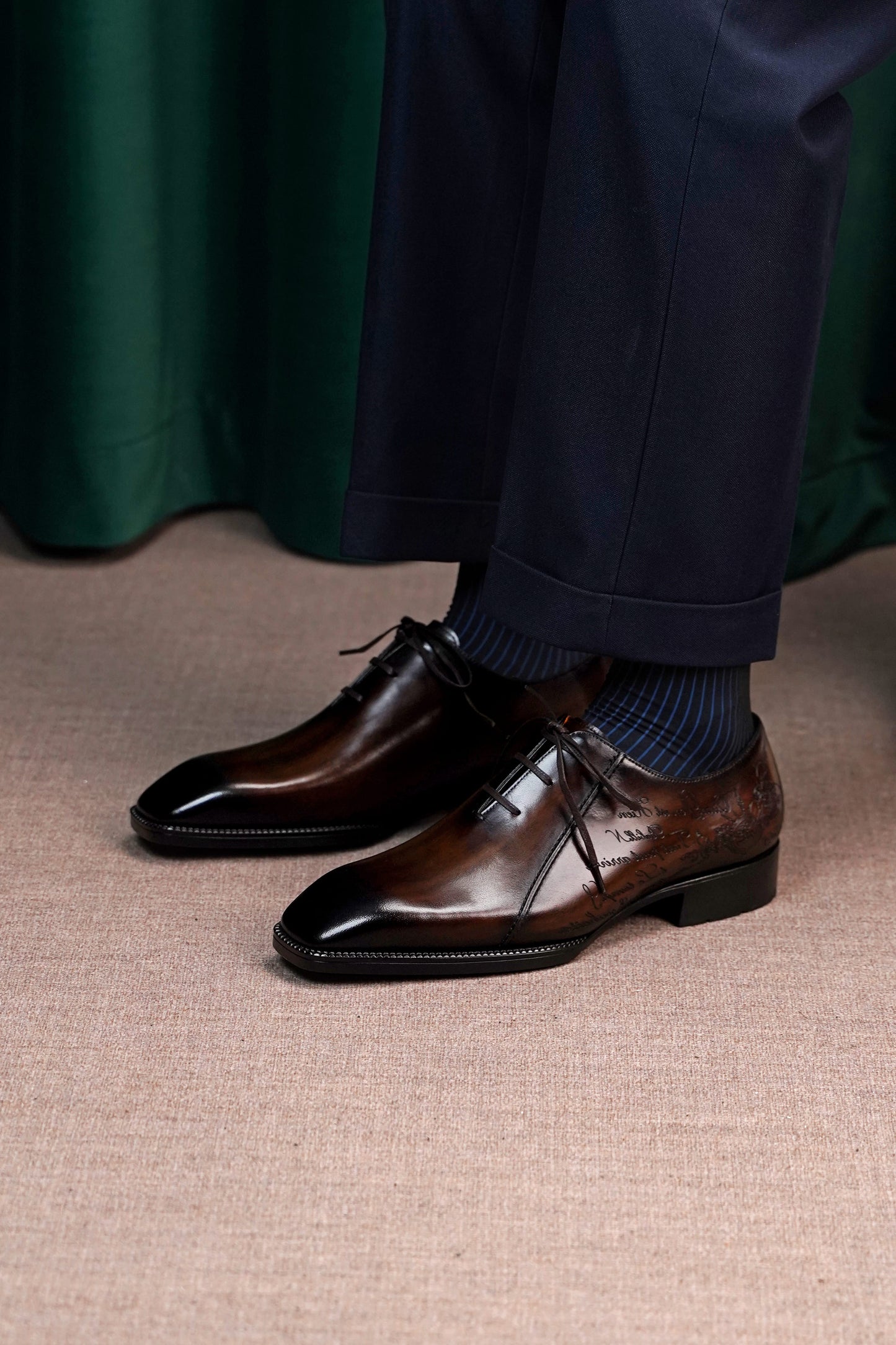 Men’s dark brown leather Oxford dress shoes with lace-up design, polished finish, pointed toe silhouette, and embossed script detail on the side panel.