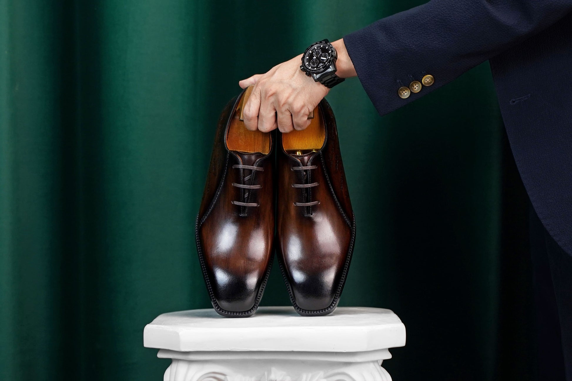 Men’s dark brown leather Oxford dress shoes with lace-up design, polished finish, pointed toe silhouette, and embossed script detail on the side panel.