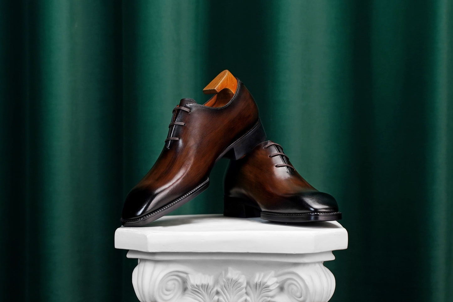 Men’s dark brown leather Oxford dress shoes with lace-up design, polished finish, pointed toe silhouette, and embossed script detail on the side panel.