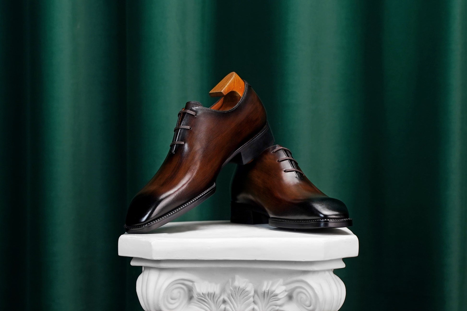 Men’s dark brown leather Oxford dress shoes with lace-up design, polished finish, pointed toe silhouette, and embossed script detail on the side panel.