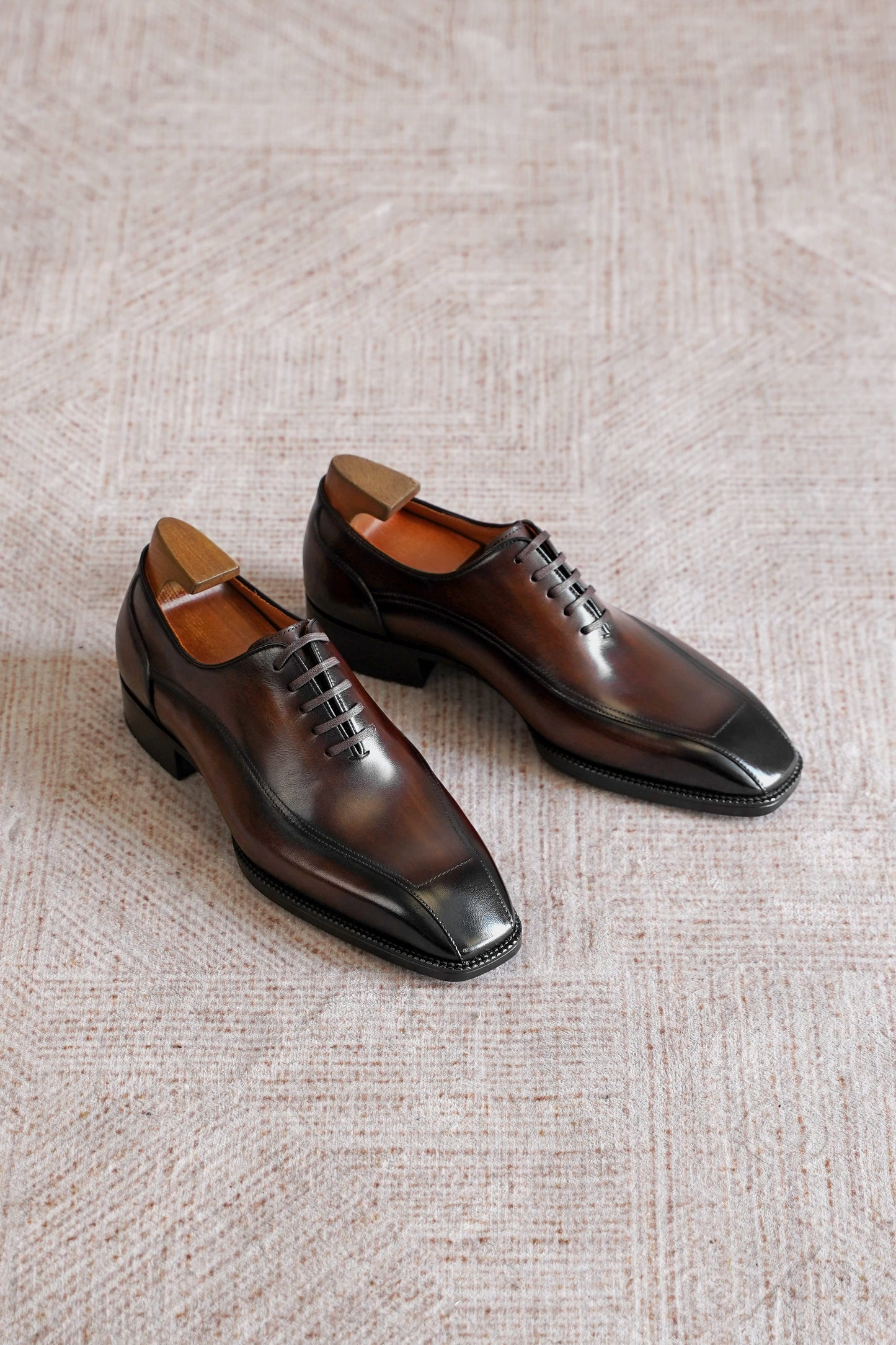 Men’s dark brown leather wholecut Oxford dress shoes with sleek lace-up design and polished formal finish.