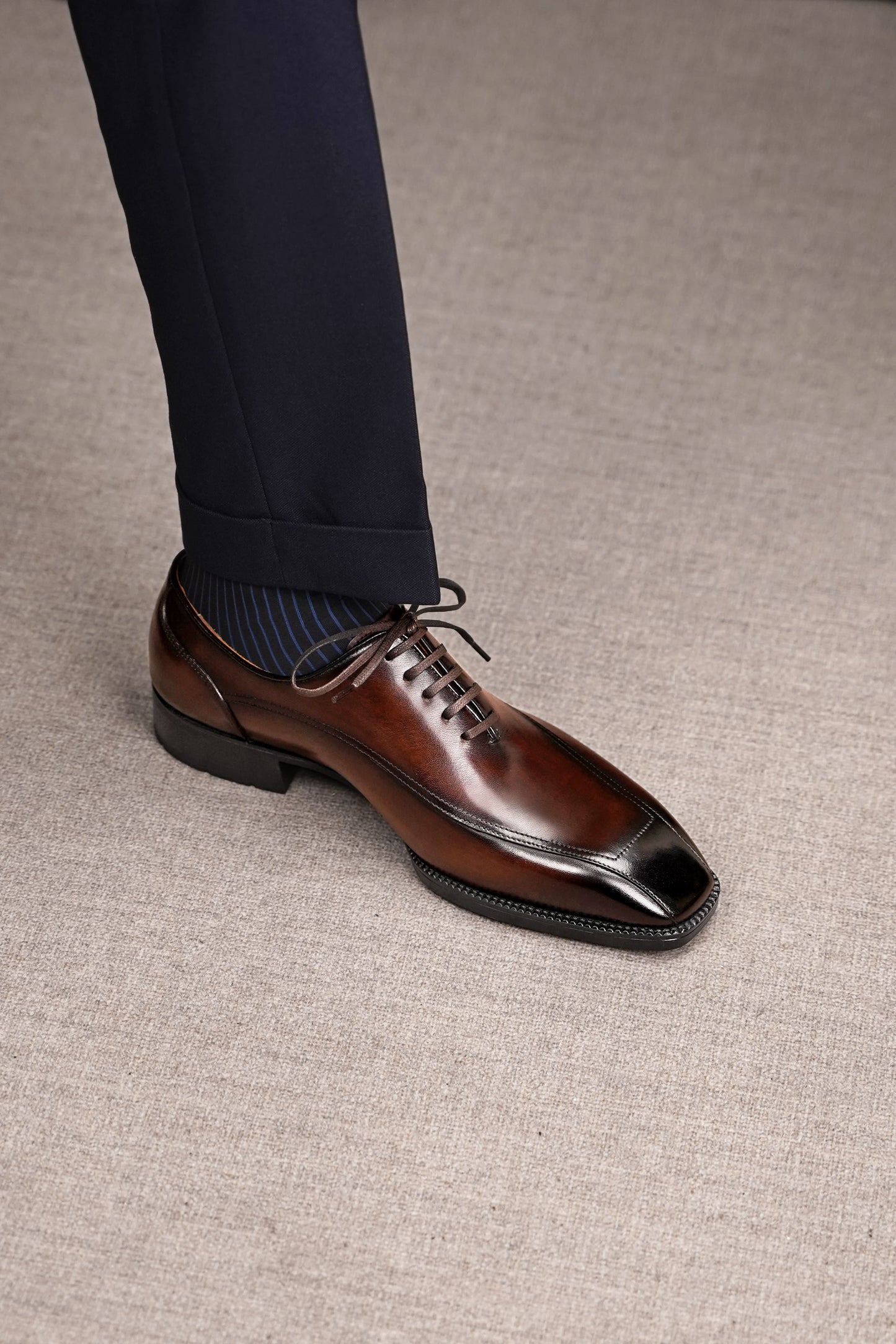 Men’s dark brown leather wholecut Oxford dress shoes with sleek lace-up design and polished formal finish.