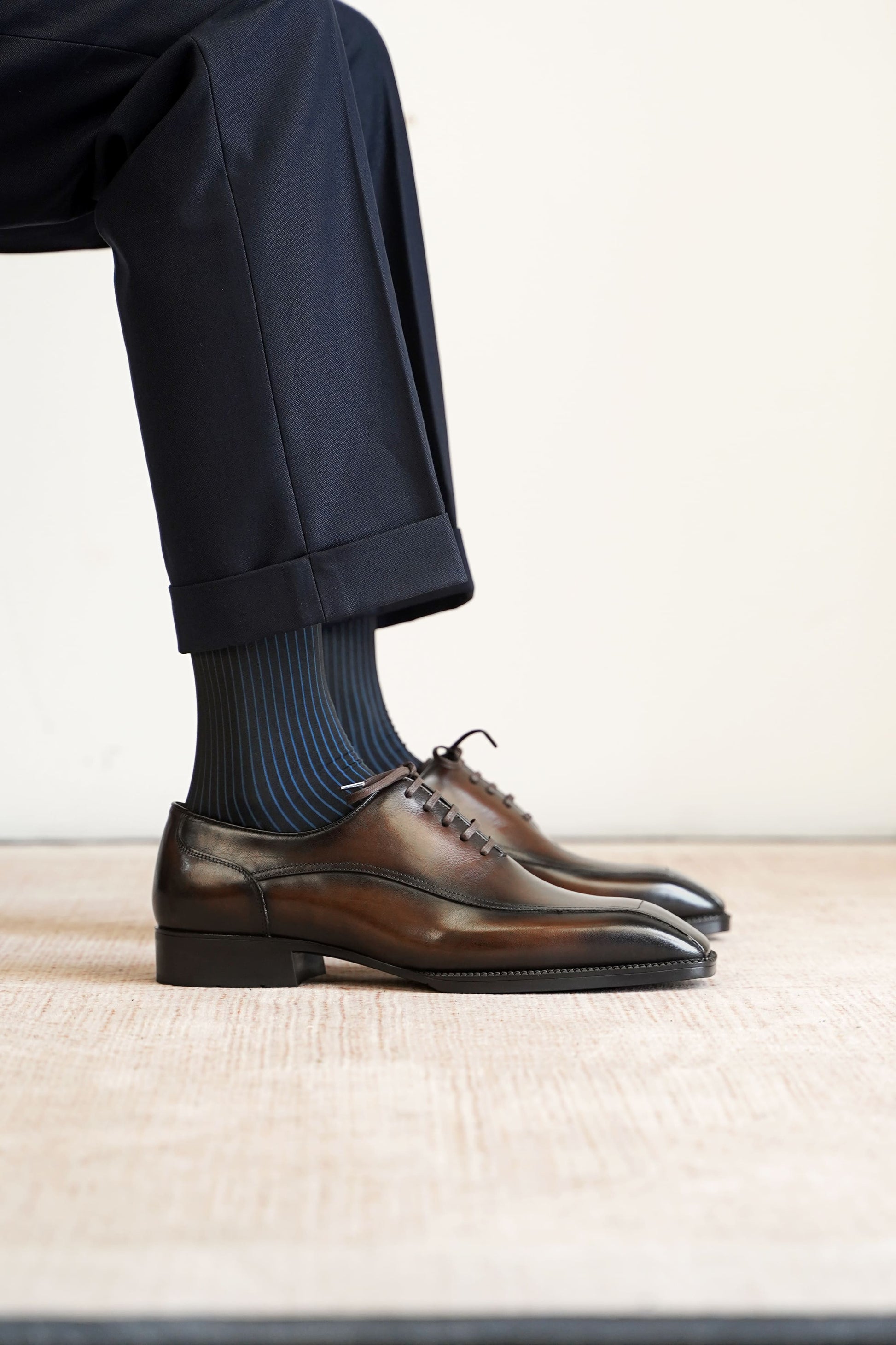 Men’s dark brown leather wholecut Oxford dress shoes with sleek lace-up design and polished formal finish.