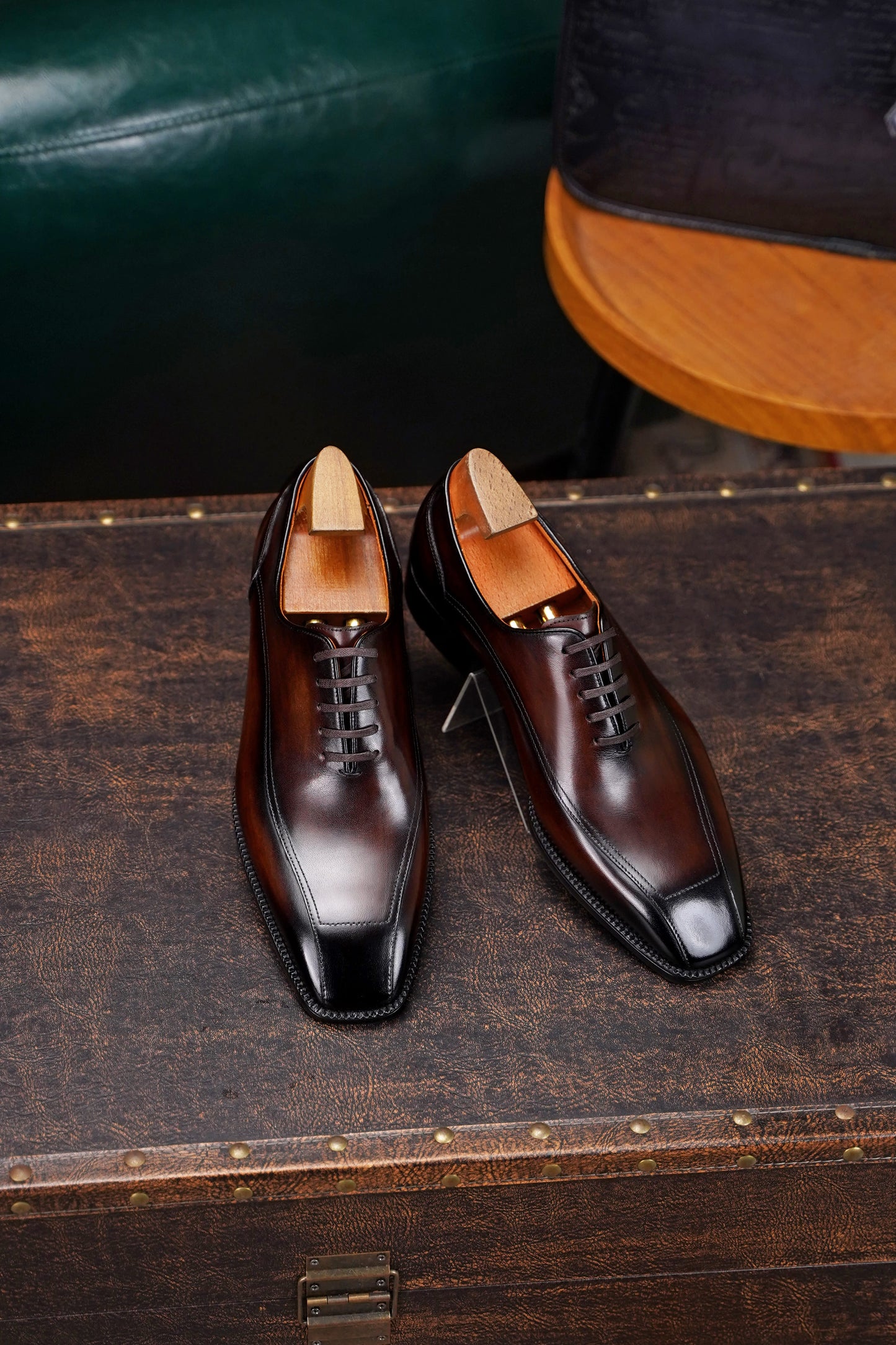 Men’s dark brown leather wholecut Oxford dress shoes with sleek lace-up design and polished formal finish.
