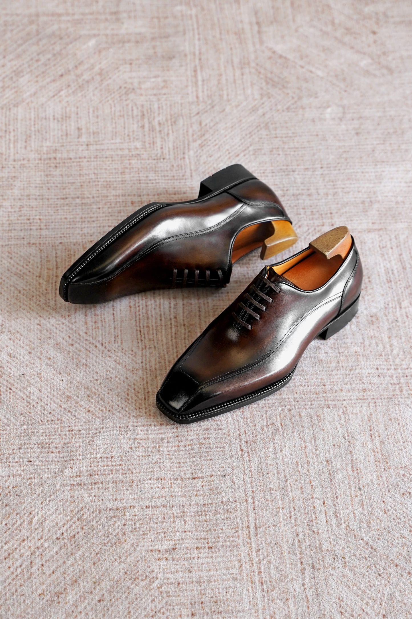Men’s dark brown leather wholecut Oxford dress shoes with sleek lace-up design and polished formal finish.