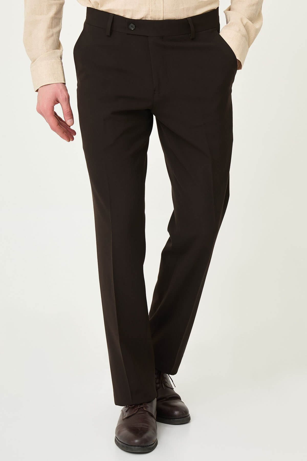 Dark brown slim-fit formal trousers with front pleats, paired with brown leather shoes.