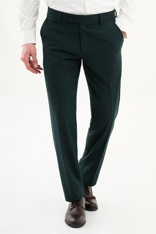 Man wearing dark green pleated dress trousers with straight slim fit, styled with a white dress shirt and brown leather shoes.