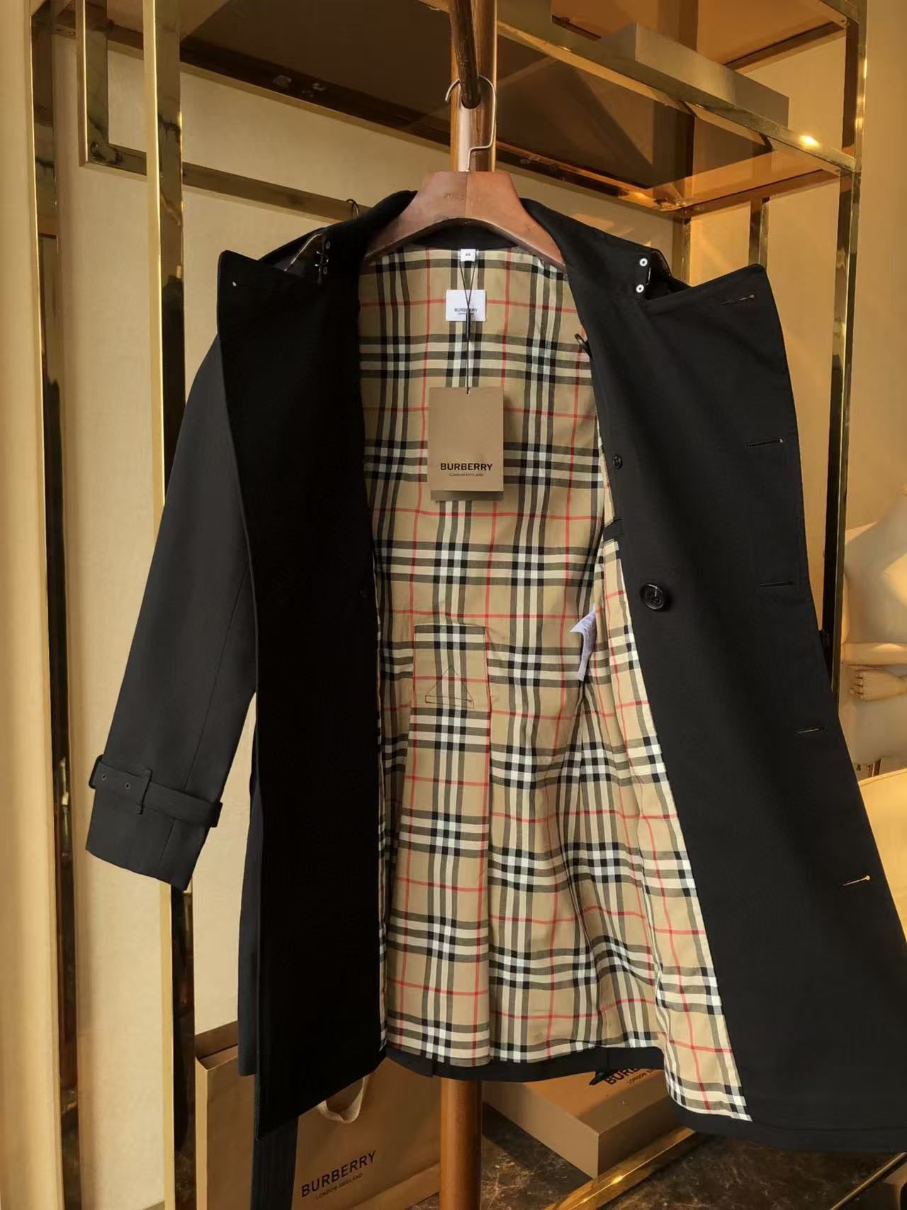 Black trench coat with a double-breasted design and adjustable belt