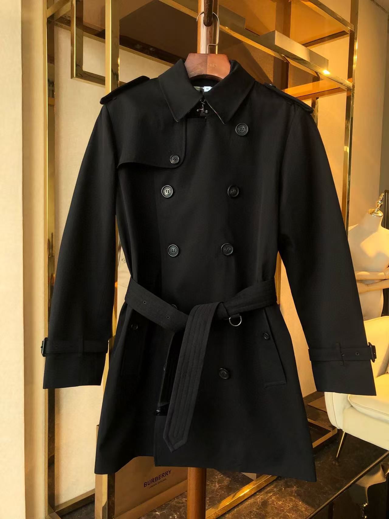 Black trench coat with a double-breasted design and adjustable belt