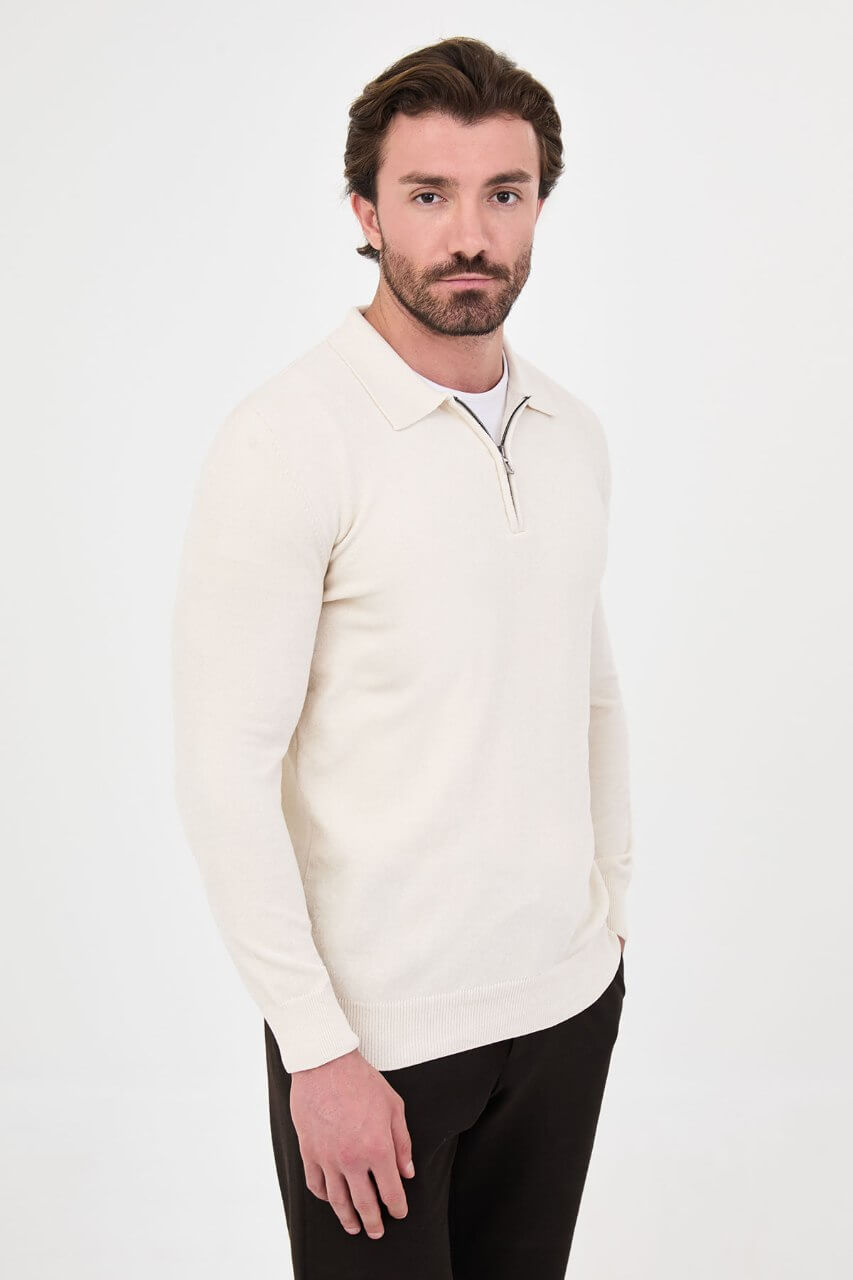 Men’s ecru polo neck knit sweater with zip collar detail styled with black trousers for a refined fall winter smart-casual outfit.