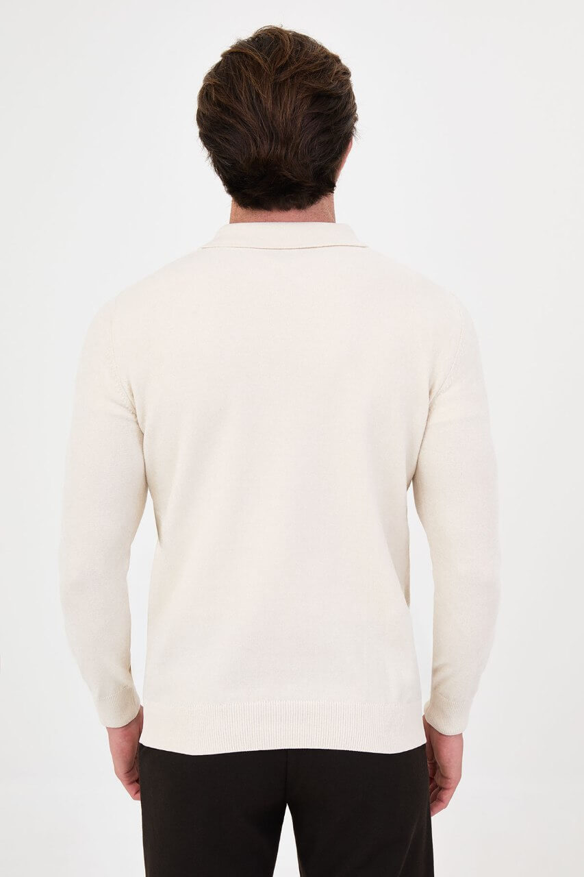 Men’s ecru polo neck knit sweater with zip collar detail styled with black trousers for a refined fall winter smart-casual outfit.