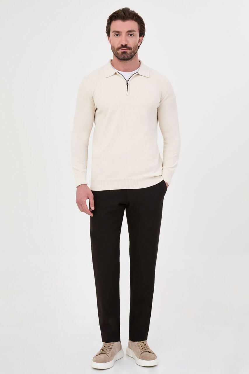 Men’s ecru polo neck knit sweater with zip collar detail styled with black trousers for a refined fall winter smart-casual outfit.